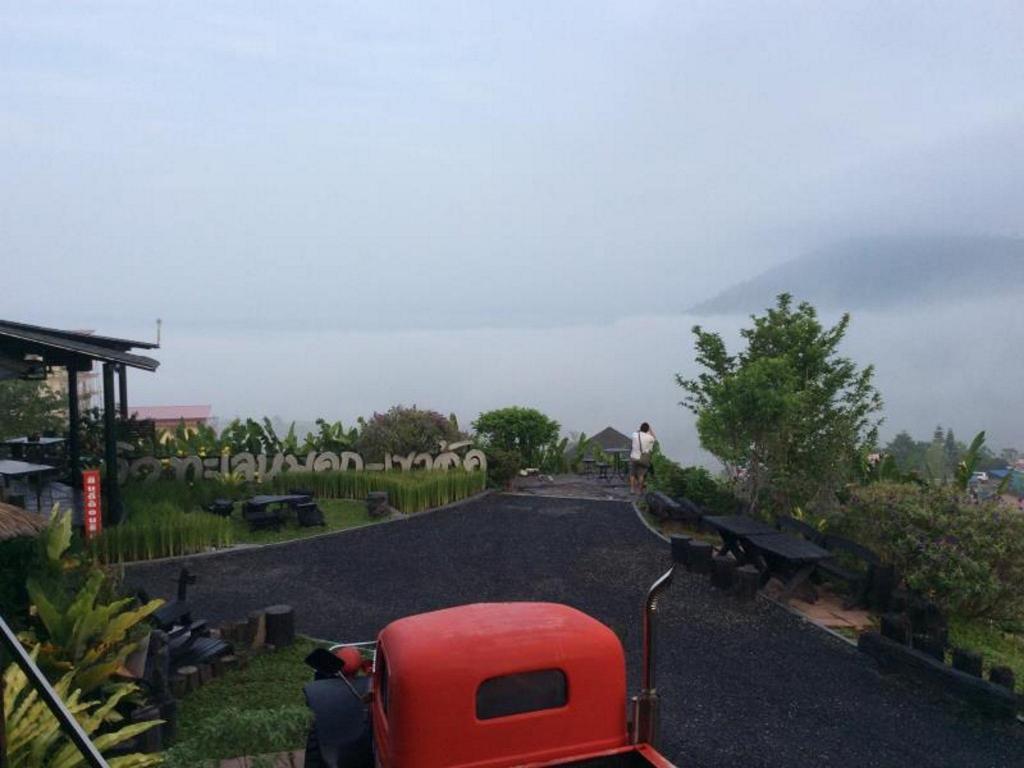 Sea of mist filling the valley seen from the resort terrace, with a Khao Kho sea-of-mist sign