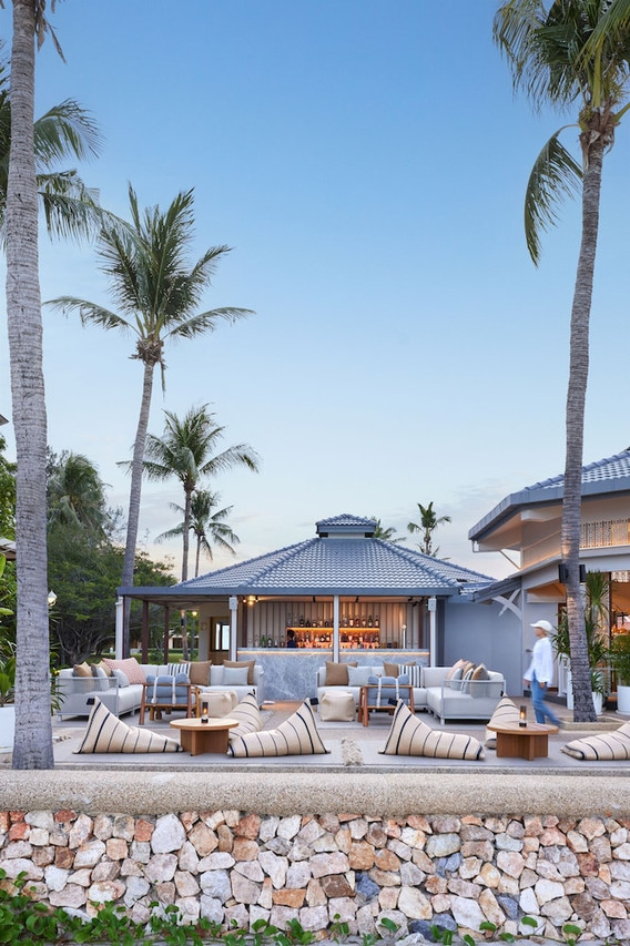 Beachside bar with a Thai-style tiled roof at dusk, facing the Gulf of Thailand