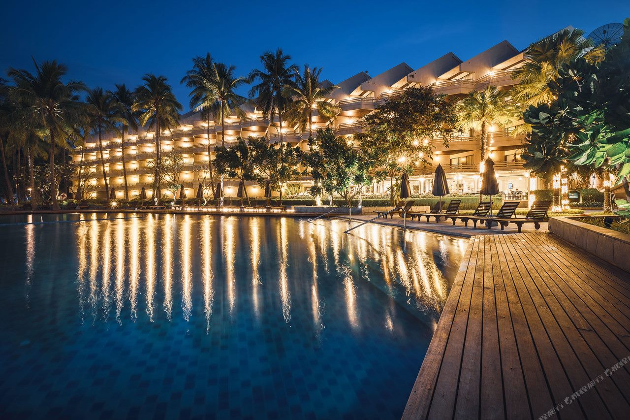 Beachfront pool at dusk reflecting the lit low-rise wing