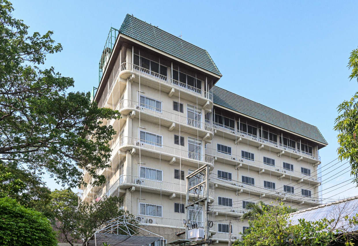 อาคารหลังคาเขียวของ Rattana Park Hotel มองจากด้านข้าง เห็นระเบียงห้องพัก