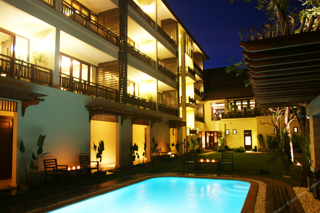 Outdoor pool and Thai teak guest-room balconies lit at night
