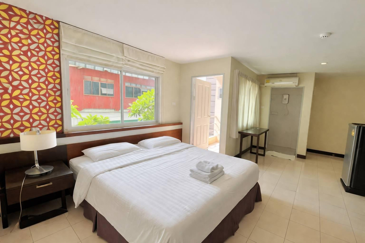 Huern Che Ta One guest room with a large bed and red-and-yellow tile headboard wall