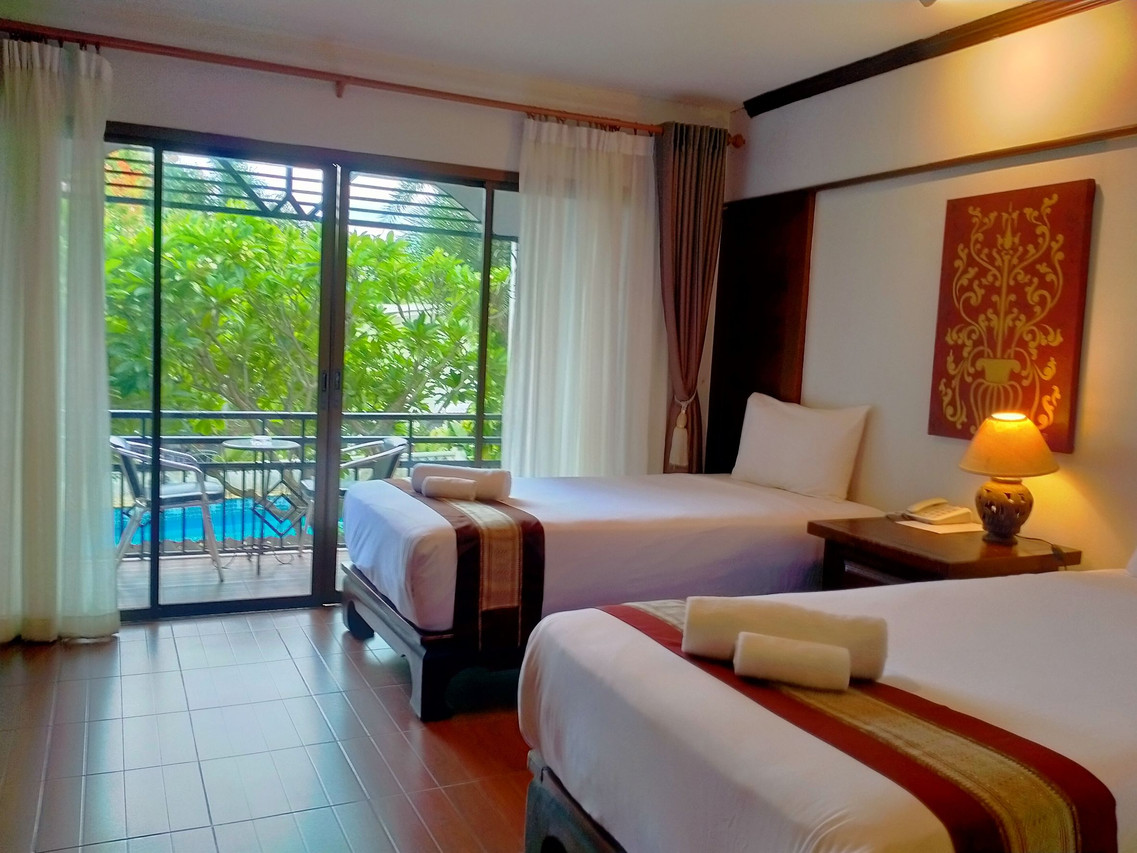 Twin room at Phoomthai Garden Hotel Phrae with a private balcony overlooking the pool and garden