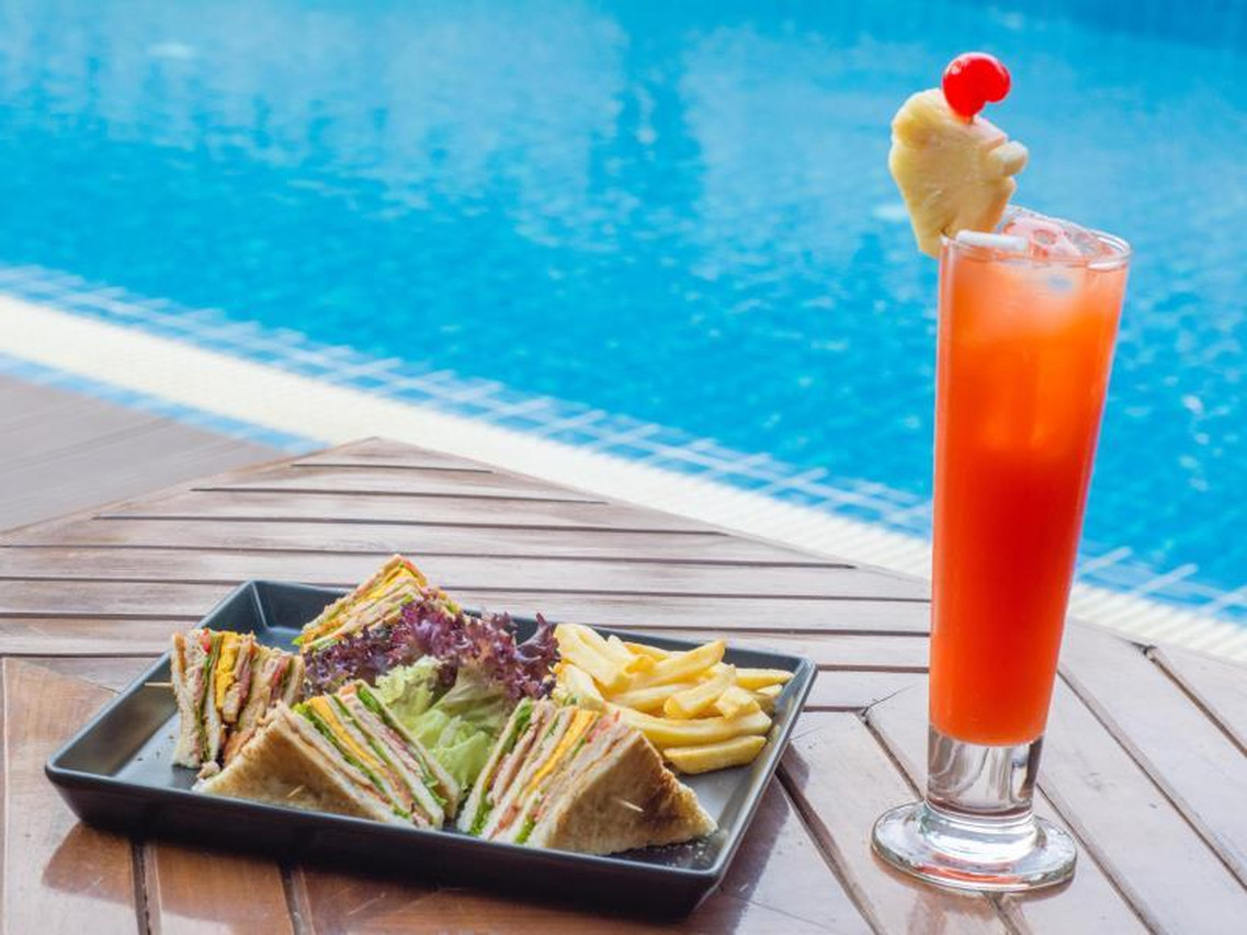 Outdoor garden swimming pool with a poolside food and drink set