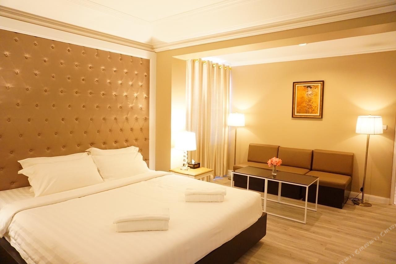 ห้อง Junior Suite ของ Taris Art Hotel Phrae เตียงใหญ่หัวเตียงบุนวมและมุมโซฟา