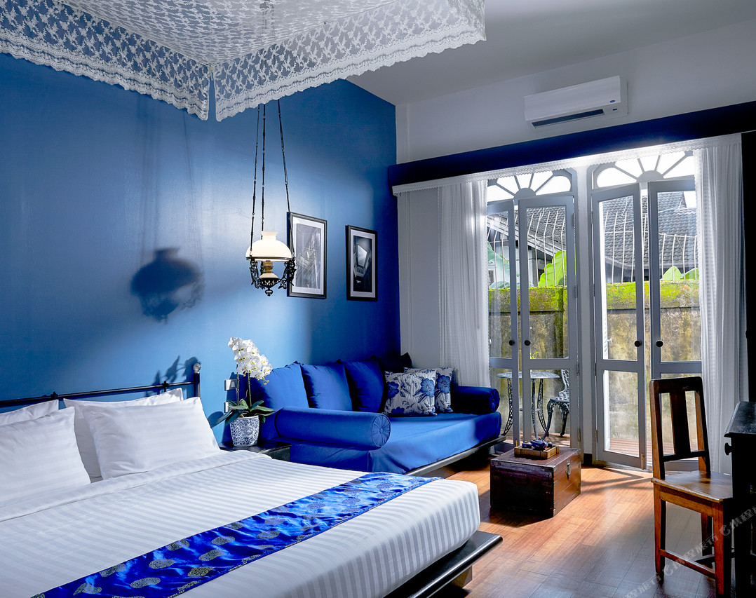 Guest room with cobalt-blue walls and a vintage lamp at The Memory at On On