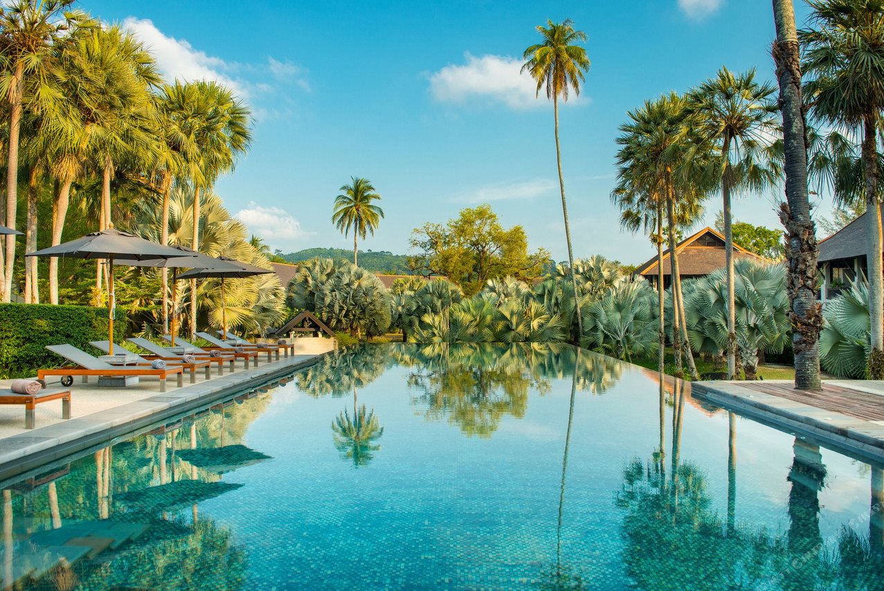 Infinity pool at The Slate Phuket framed by palms and hills