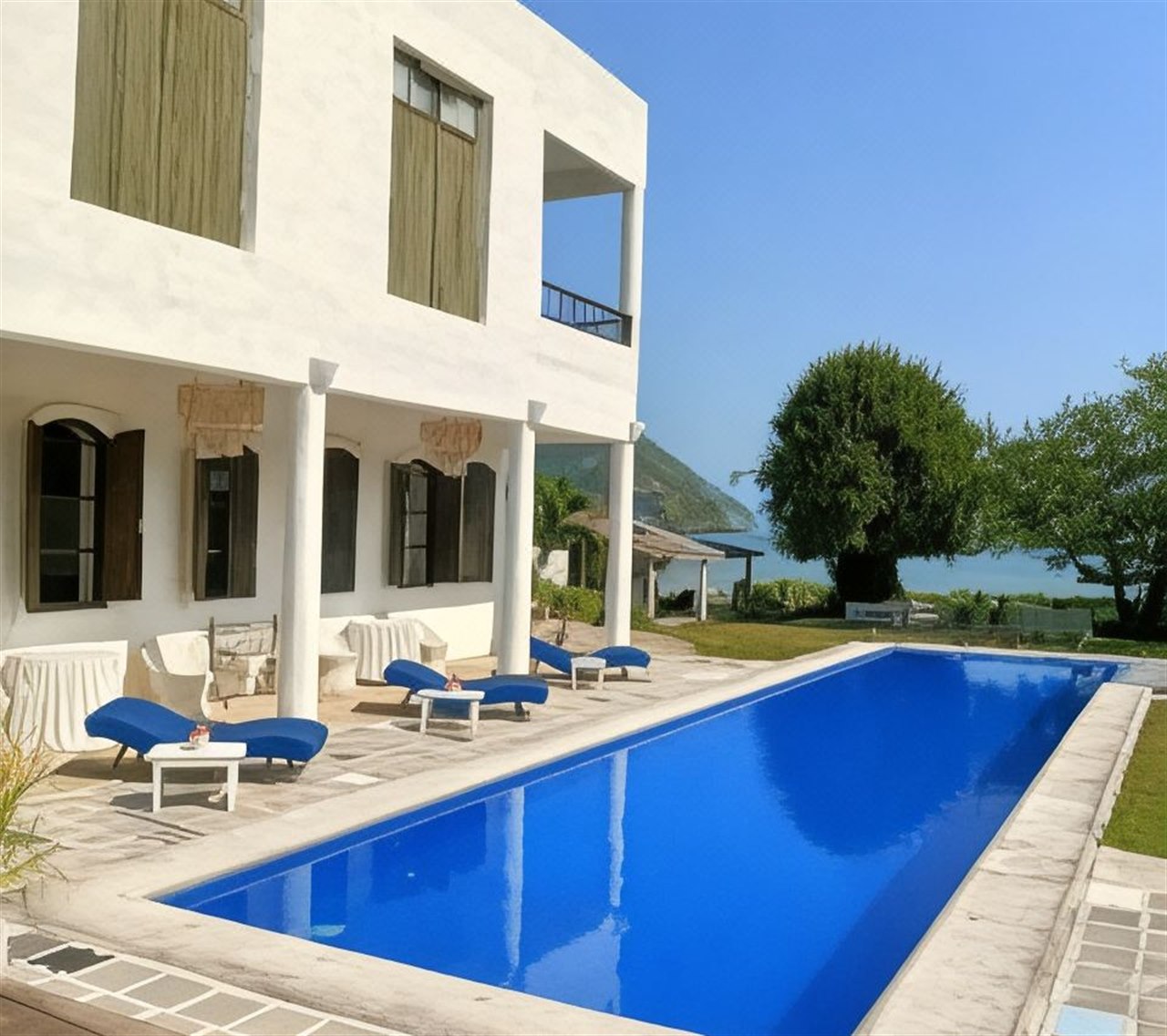 Seafront lap pool at Brassiere Cozy Beach with white villas alongside