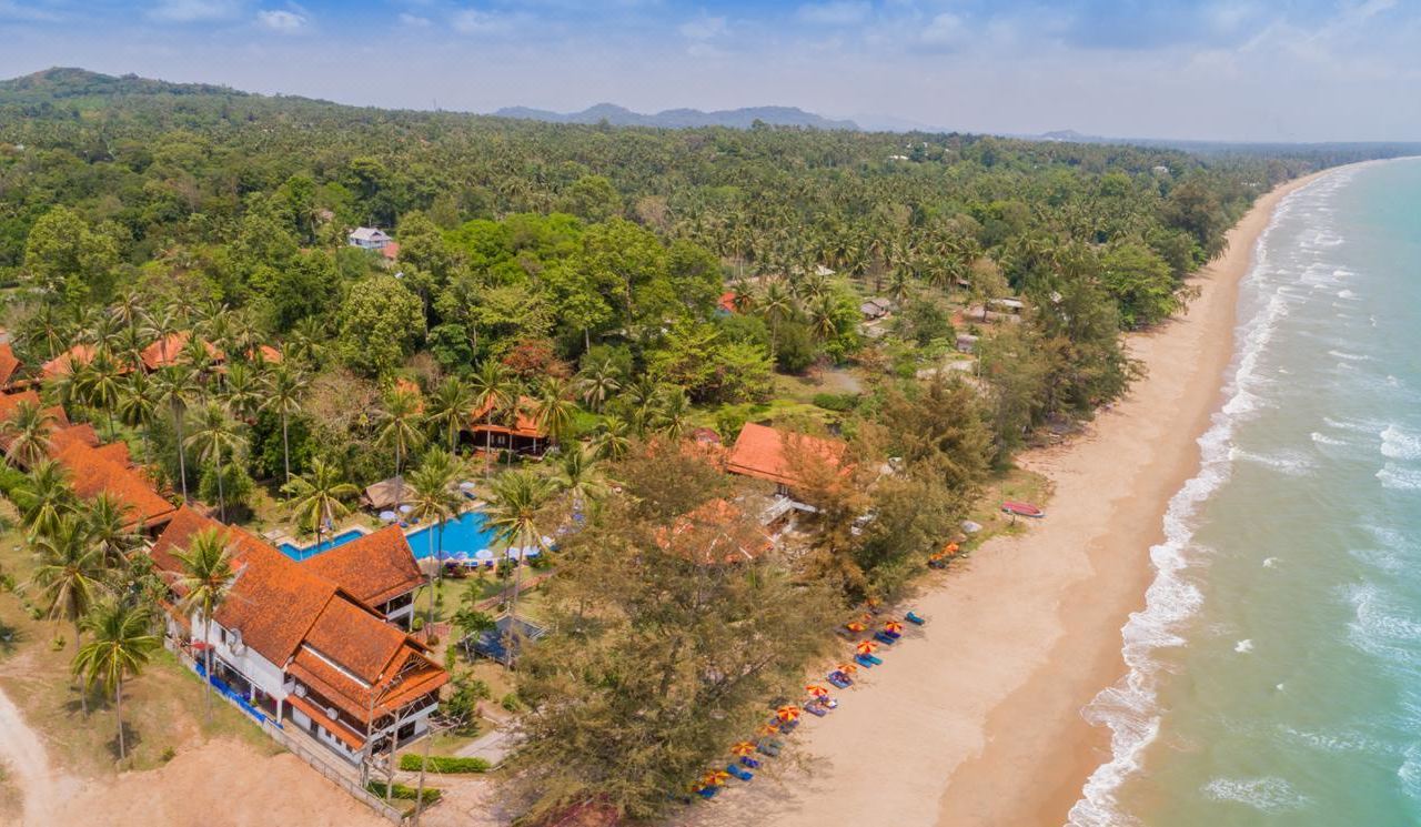 Beachfront resort along Suan Luang Beach with sun loungers on the sand