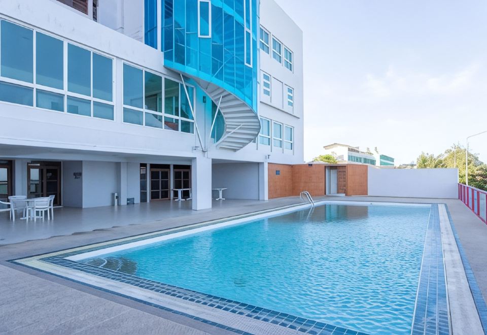 สระว่ายน้ำกลางแจ้งของ Hadthong Hotel พร้อมอาคารกระจกสีฟ้า