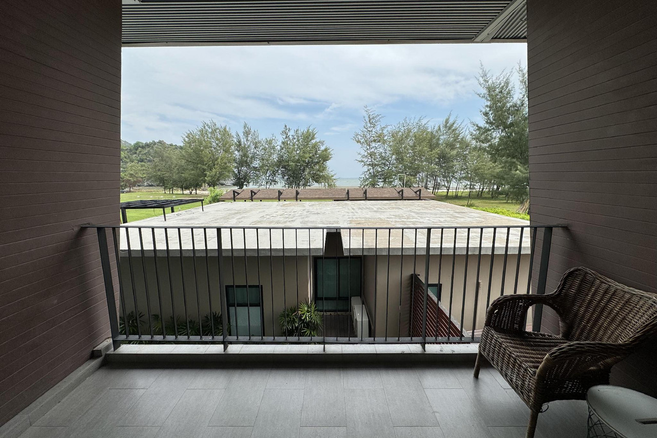 ระเบียงห้องพักมองออกไปทางแนวสนทะเลและชายหาด