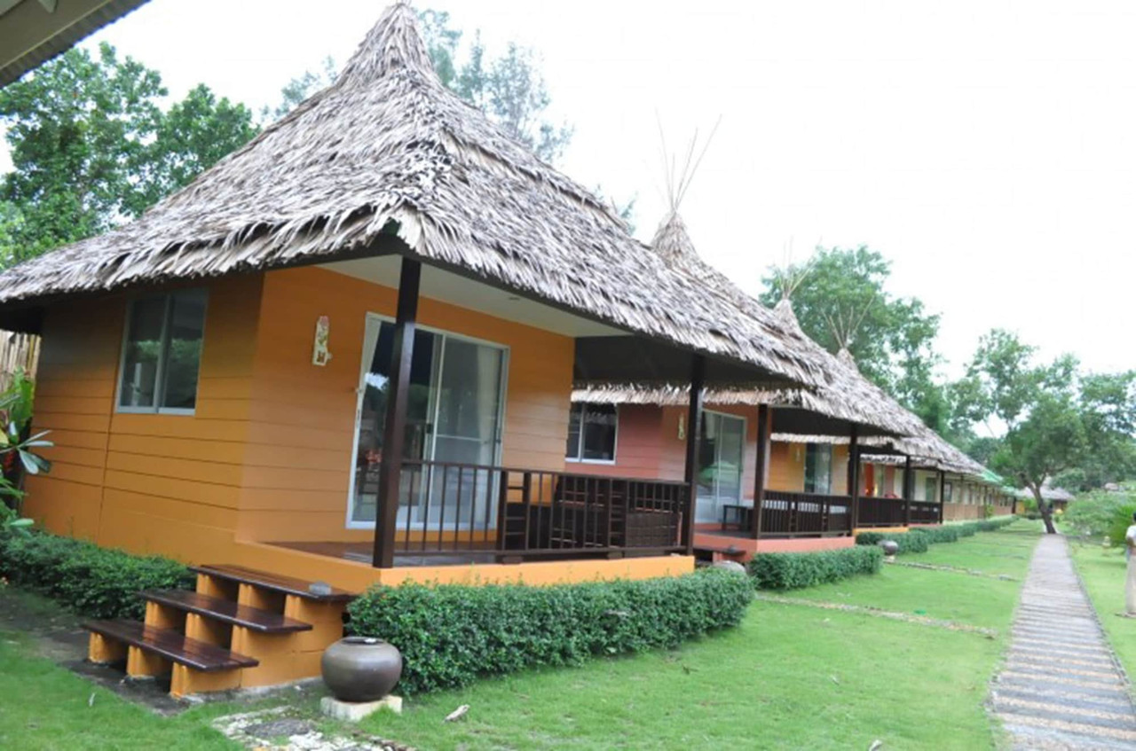 บังกะโลหลังคาจากสีส้มเรียงในสวนที่ Phayam Cottage Resort เกาะพยาม