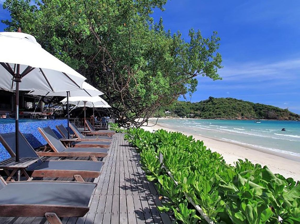 White umbrellas and sun loungers lined along the white-sand Ao Prao beach