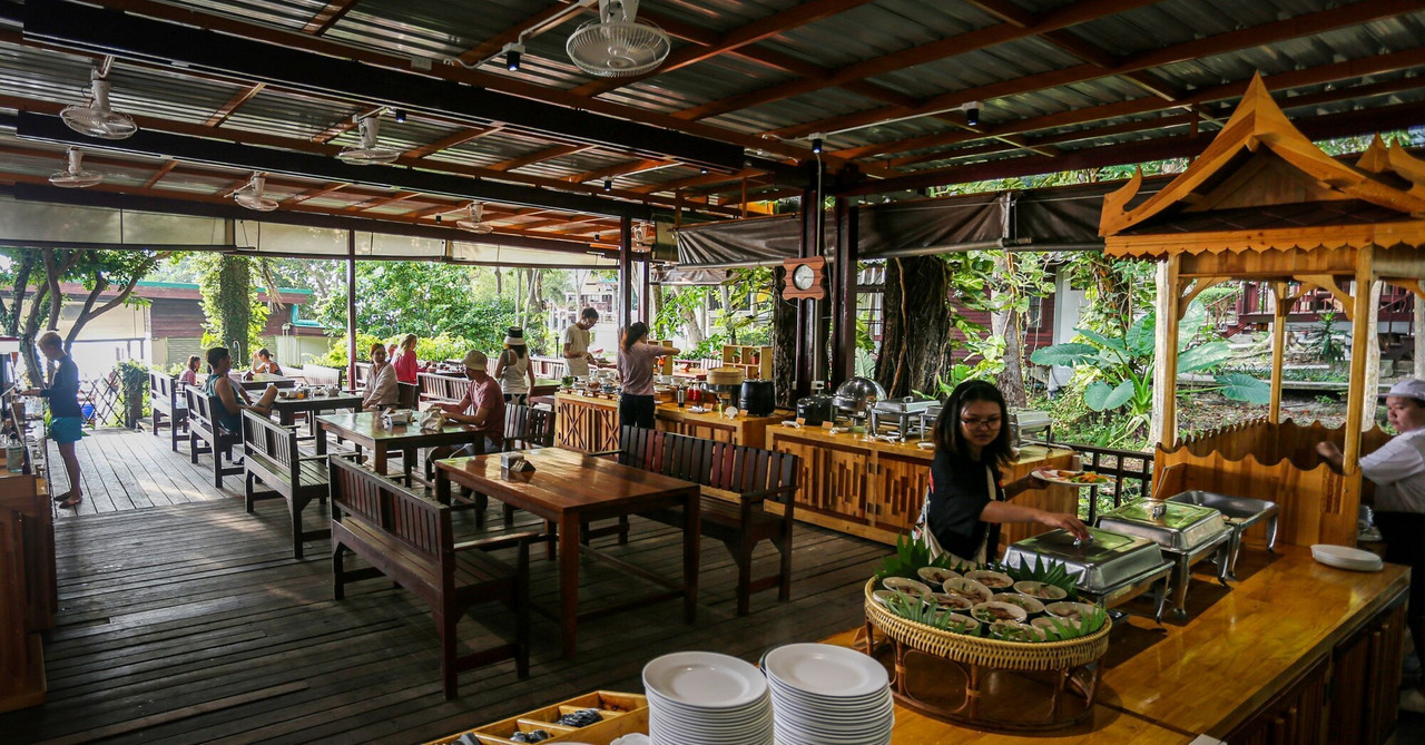 Open-air beachfront restaurant with a breakfast buffet line
