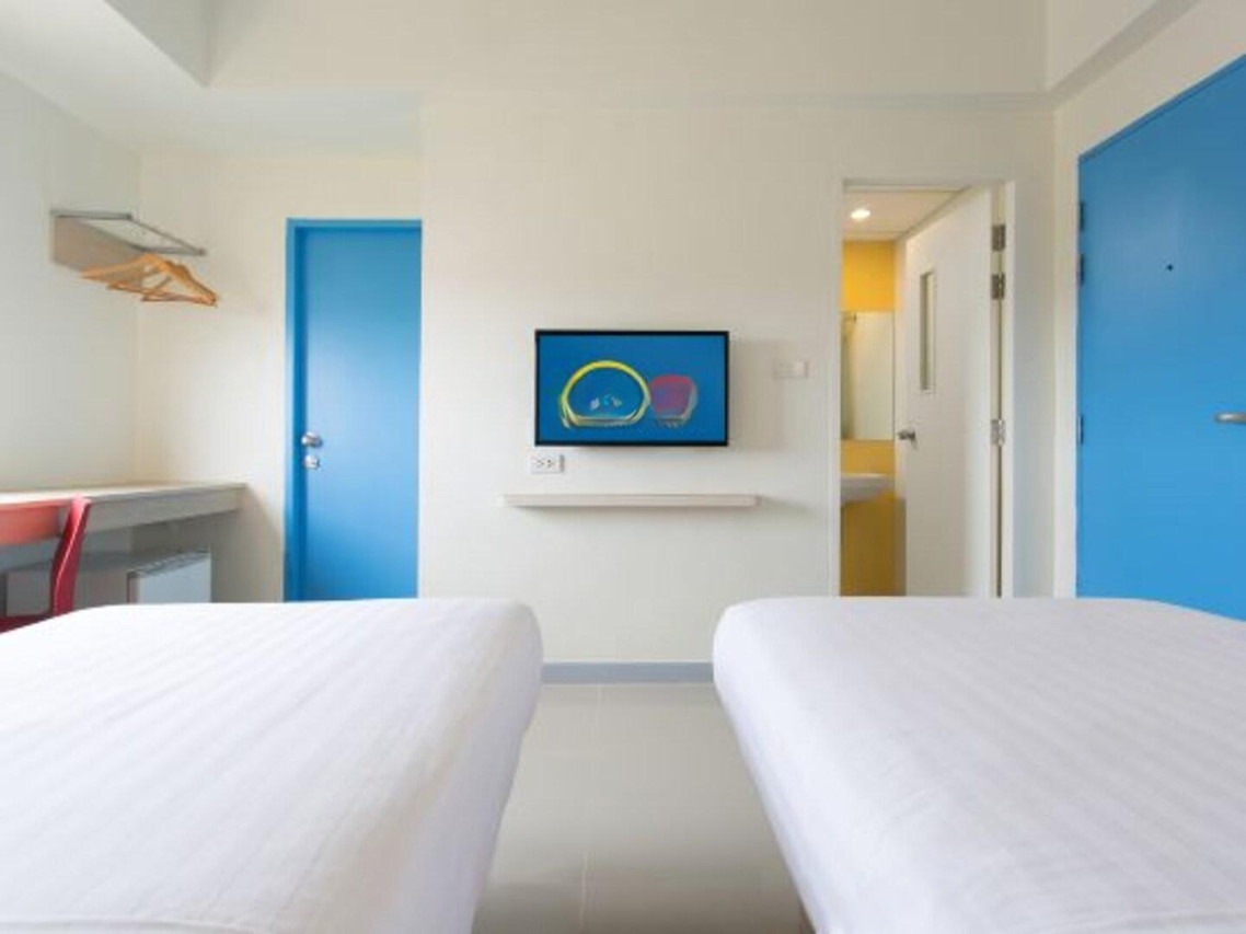 Standard Twin room with two single beds and the brand's blue doors at Hop Inn Sa Kaeo