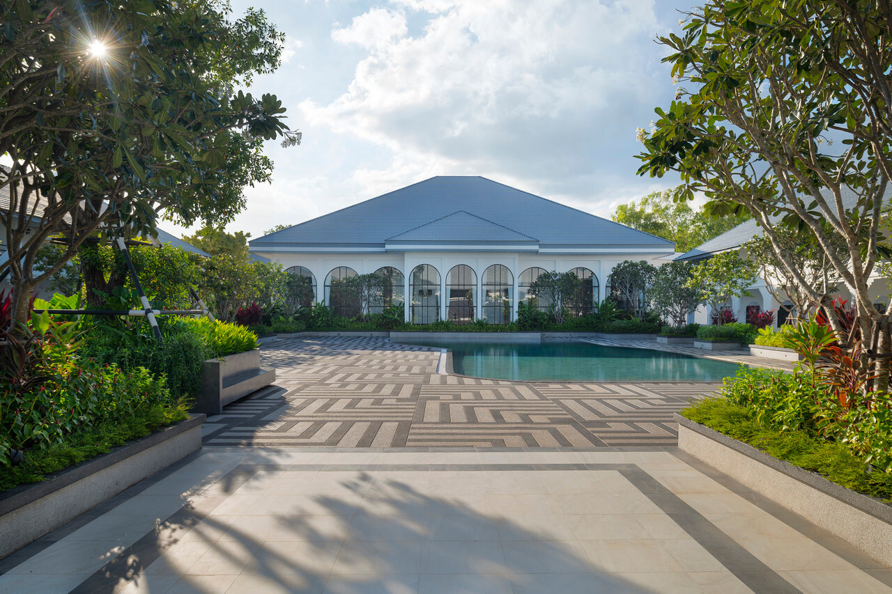 Courtyard pool with the white arched-veranda building in daylight