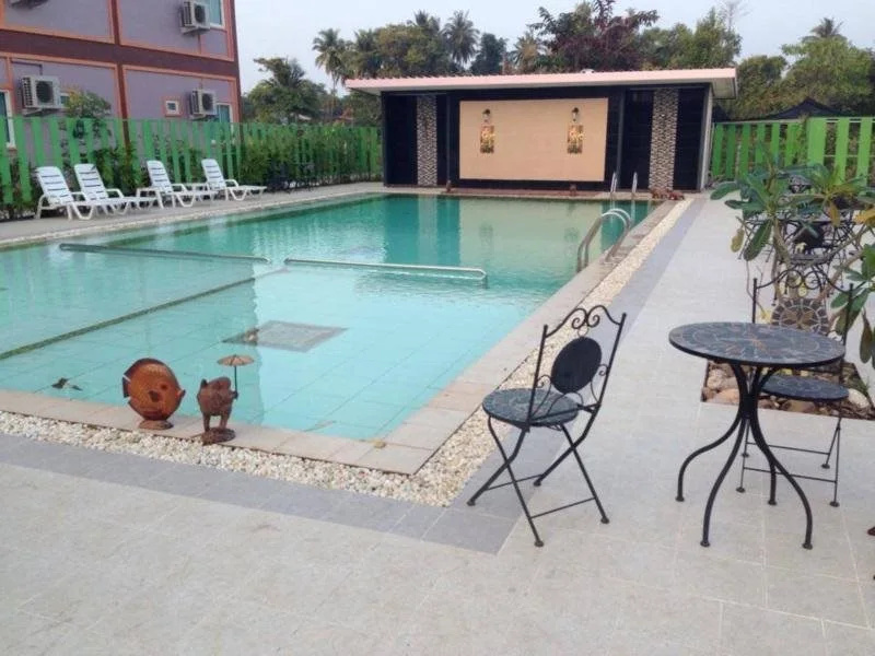 Salt-water outdoor pool with sun loungers and a small stage pavilion by the water