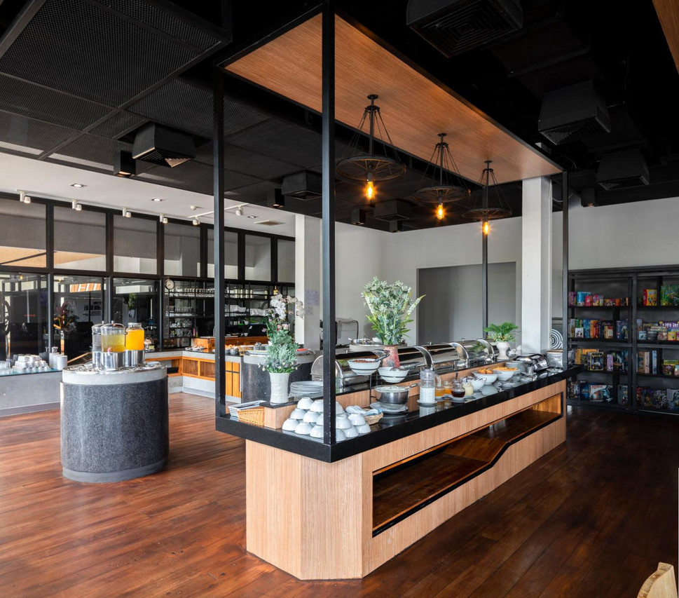 Breakfast and Big Bite café area with bicycle-wheel pendant lights and board-game shelves