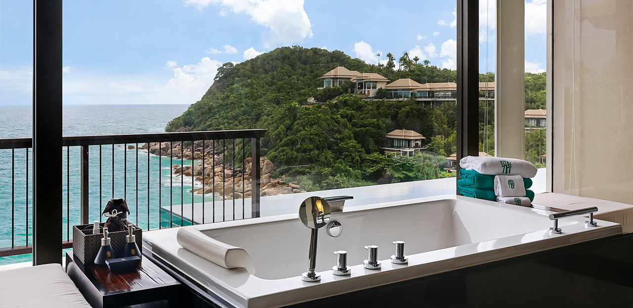 Villa bathtub framing the sea and hillside villas at Banyan Tree Samui