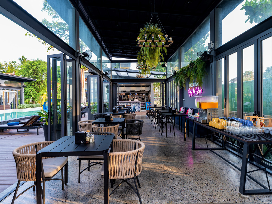 บาร์และร้านอาหารกึ่งกลางแจ้งเปิดสู่สระและสวน