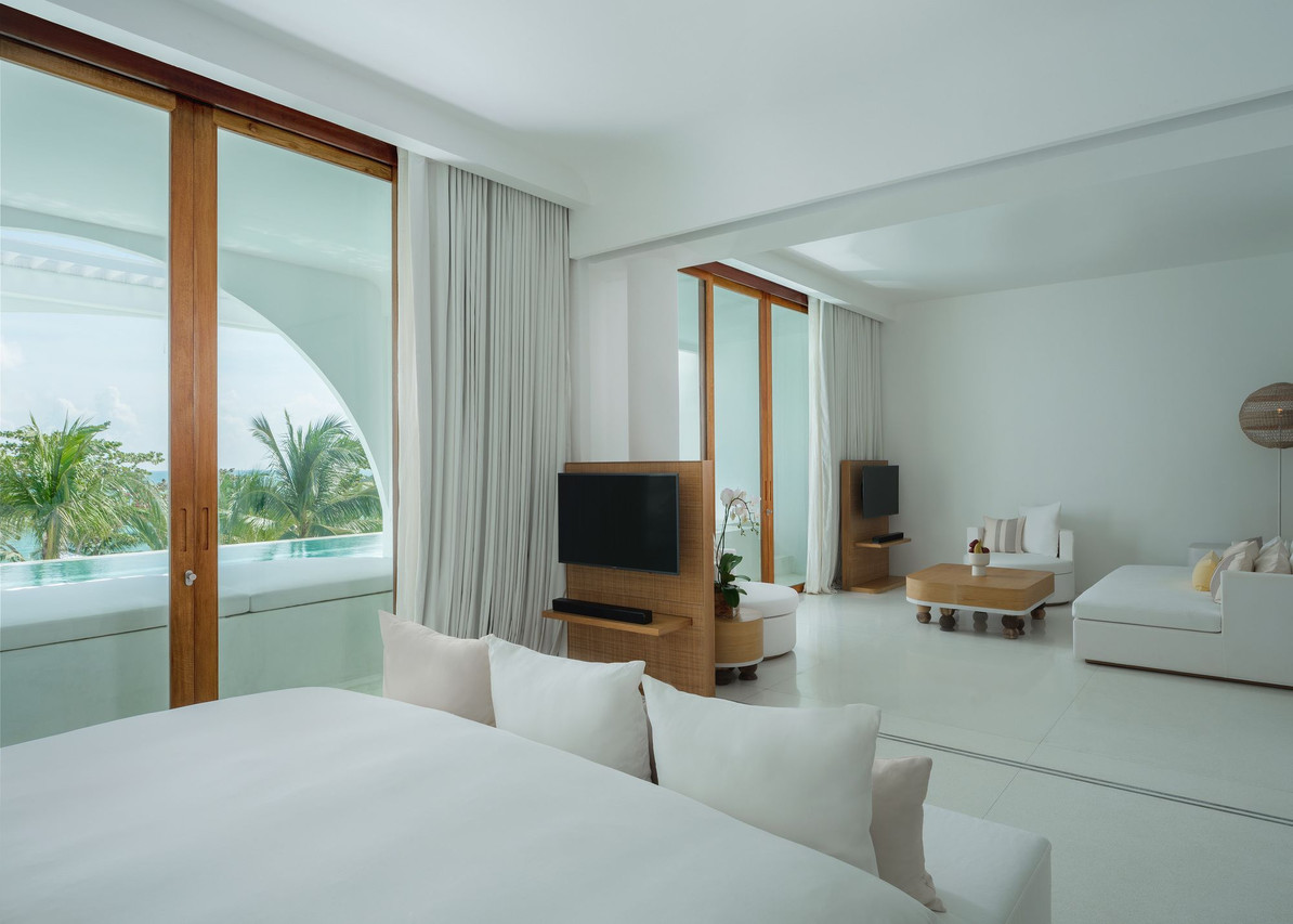 White-and-beige room opening onto a private pool with sea view
