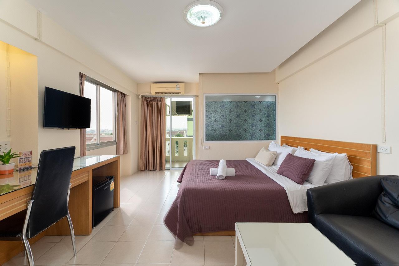 ห้องพัก J.Residence Samutprakarn กว้างแบบสตูดิโอ มีเตียงคิง โซฟาหนัง ตู้เย็น และระเบียง
