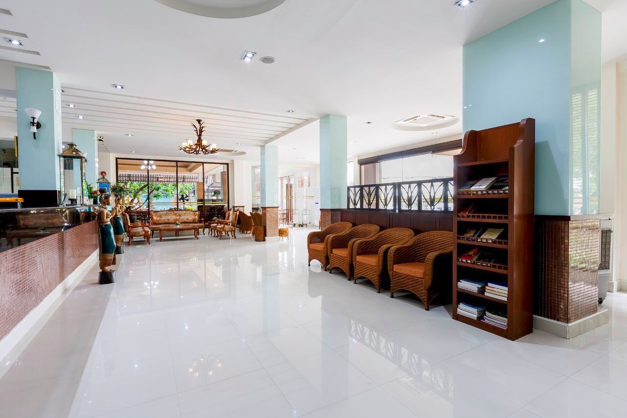 White-tiled lobby with rattan chairs and Thai-style decor