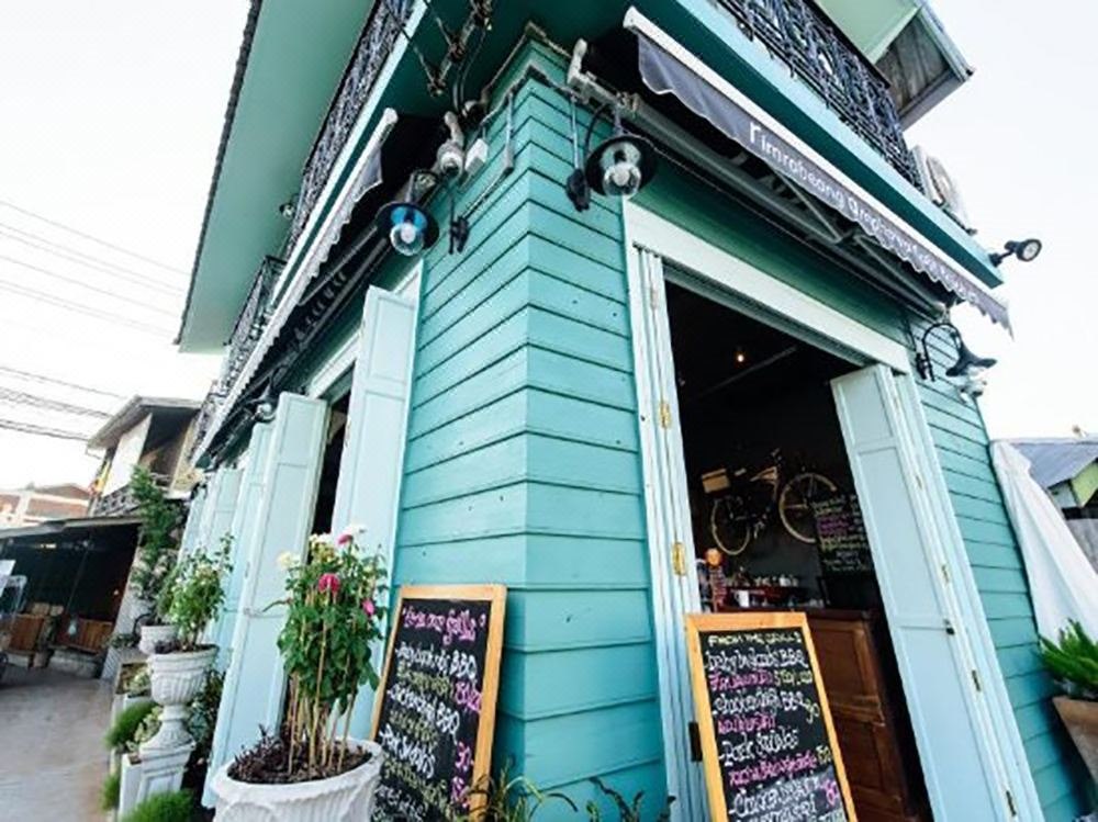 อาคารไม้สีเขียวเทอร์คอยซ์ของ Baanrabiang ริมคลองอัมพวา ชั้นล่างเป็นคาเฟ่