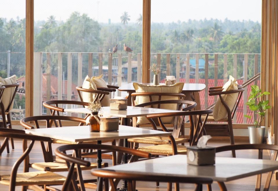 รูฟท็อปคาเฟ่ของ Amphawa Na Non มองเห็นหลังคาบ้านและสวนมะพร้าวย่านอัมพวา