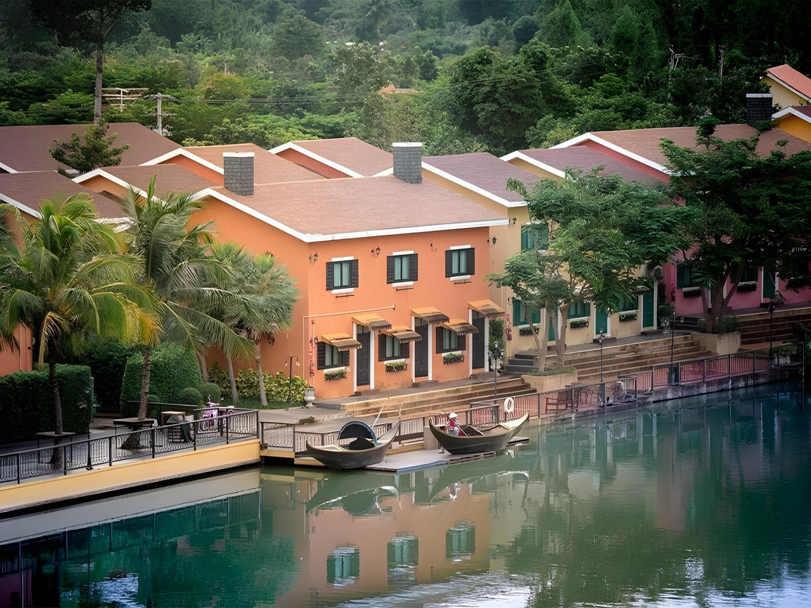 Terracotta Italian-style buildings beside the lake with gondolas moored