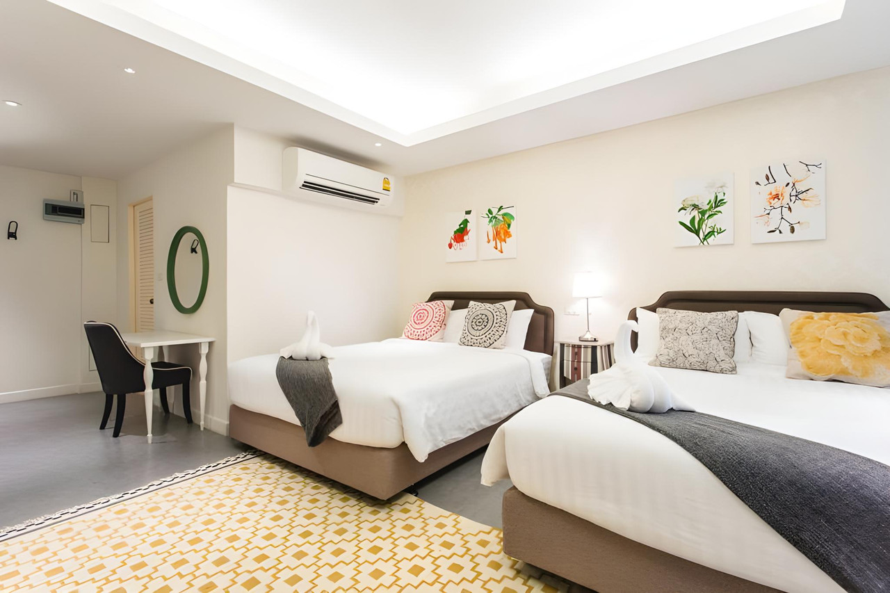 Bright, spacious twin guest room with floral artwork at The Verona at Tublan