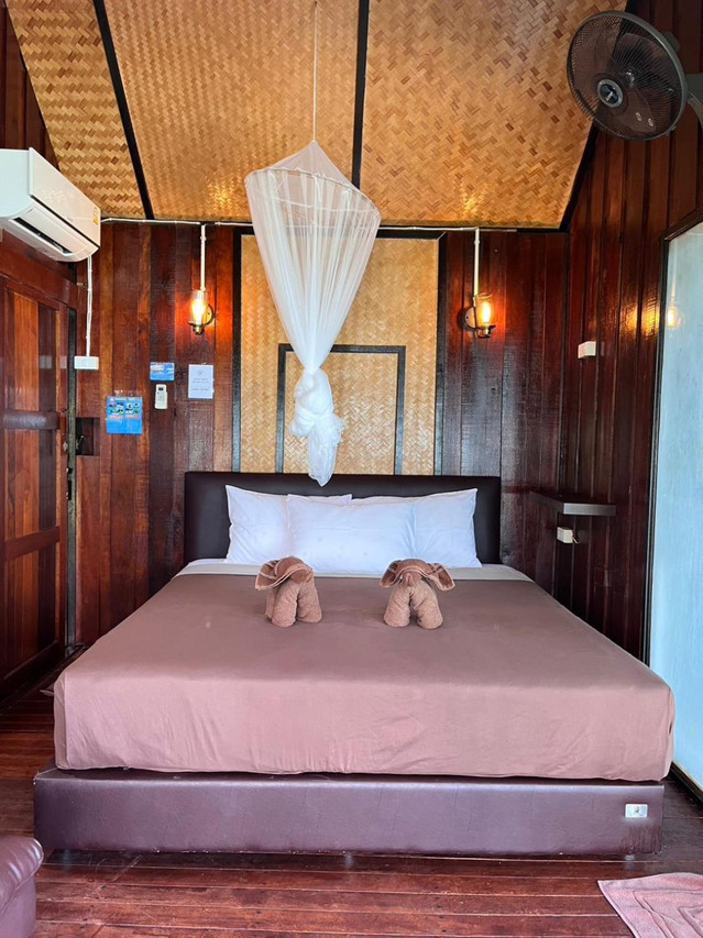 Wood-panelled room with bamboo ceiling and a mosquito net over the bed