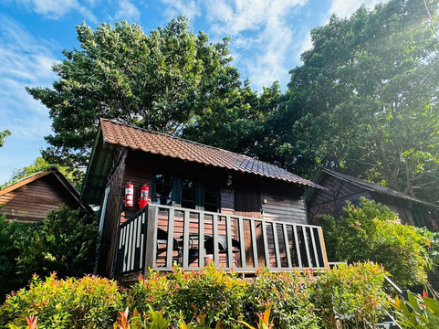 Wooden bungalow with a balcony among the resort's trees