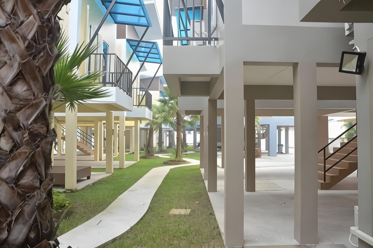 Two-storey garden bungalows with concrete walkway and palm trees