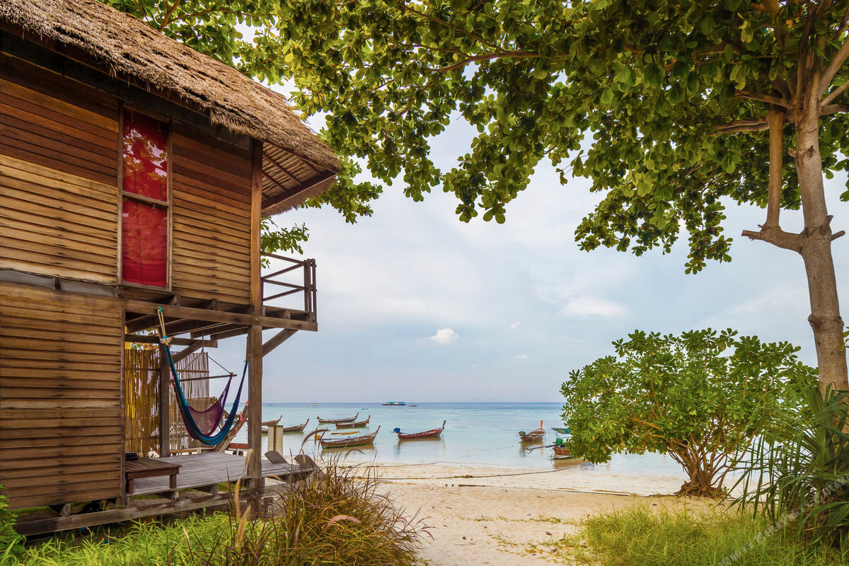 Beachfront wooden bungalow with hammock and longtail boats on Sunrise Beach