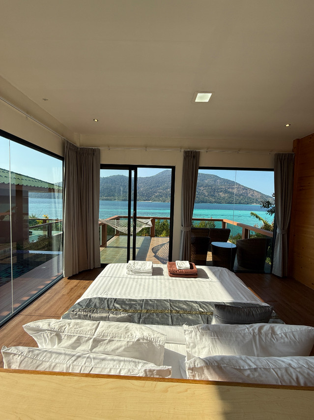 Pool Villa bedroom with floor-to-ceiling glass opening to sea and Koh Adang views