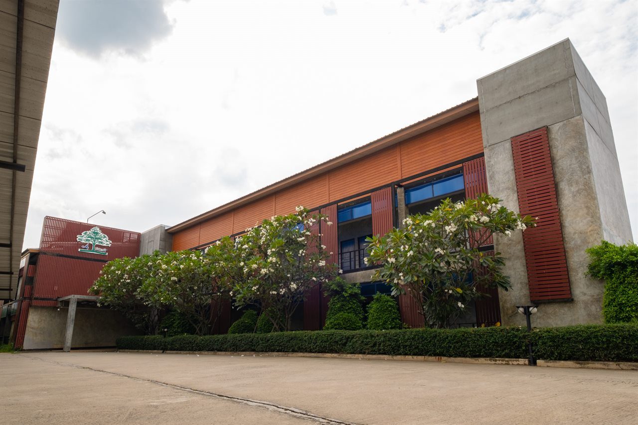 Two-storey building at Buaksee Resort with frangipani trees in daylight