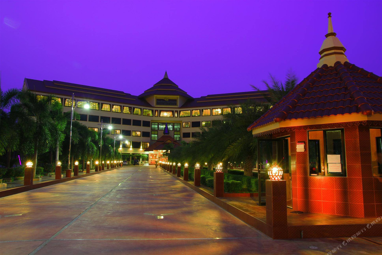 Golden Dragon Resort Sing Buri entrance at dusk, the long driveway lit on both sides