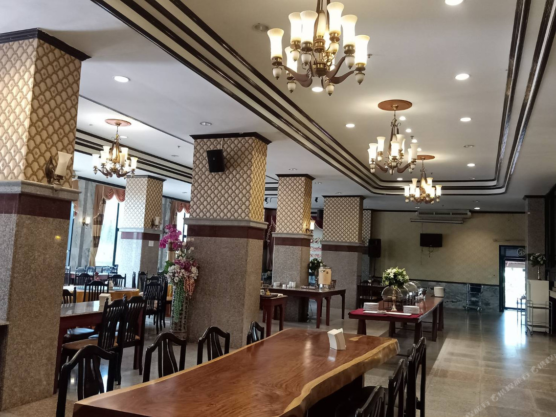 Leelawadee restaurant hall with a large timber table, chandeliers and a breakfast buffet counter