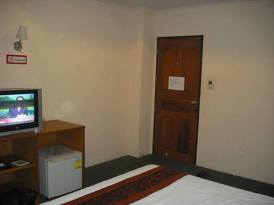 Twin-bed room at Grand Leo Hotel with carpet and Thai-pattern bed runners