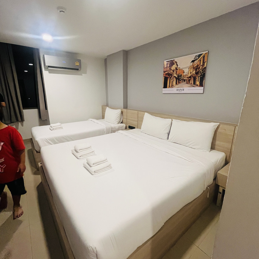 ห้อง Deluxe Triple เตียงคู่บวกเตียงเดี่ยว ผนังโทนเทากับภาพ Hanoi