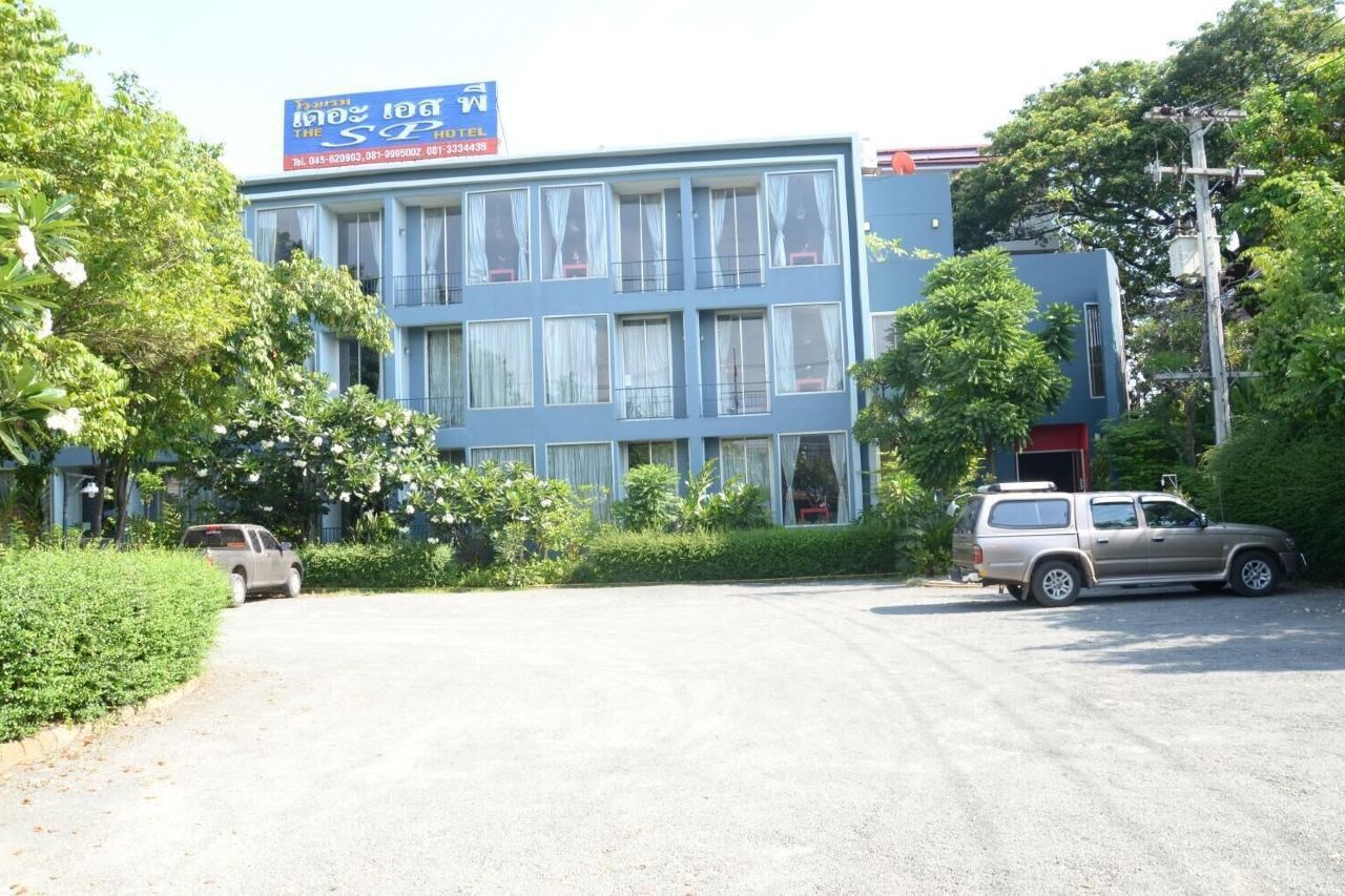 อาคาร The SP Hotel ทาสีฟ้า มีป้ายชื่อโรงแรม ลานจอดรถกว้างหน้าตึก