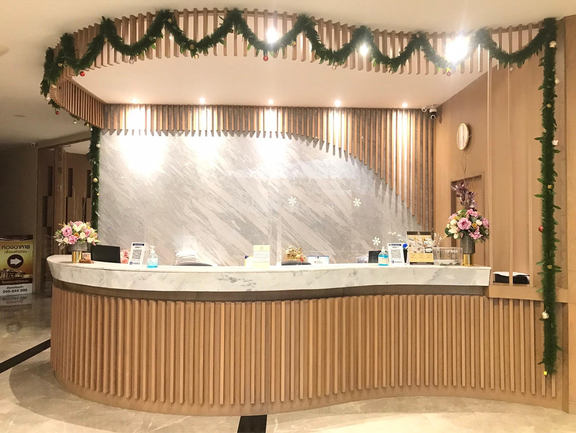 เคาน์เตอร์ต้อนรับหินอ่อนและไม้ระแนงในล็อบบี้ Srilamduan Hotel