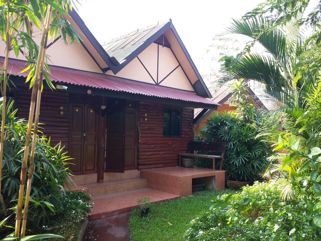 Detached wooden bungalow with a porch in the garden at Ban Thai Guesthouse Sukhothai