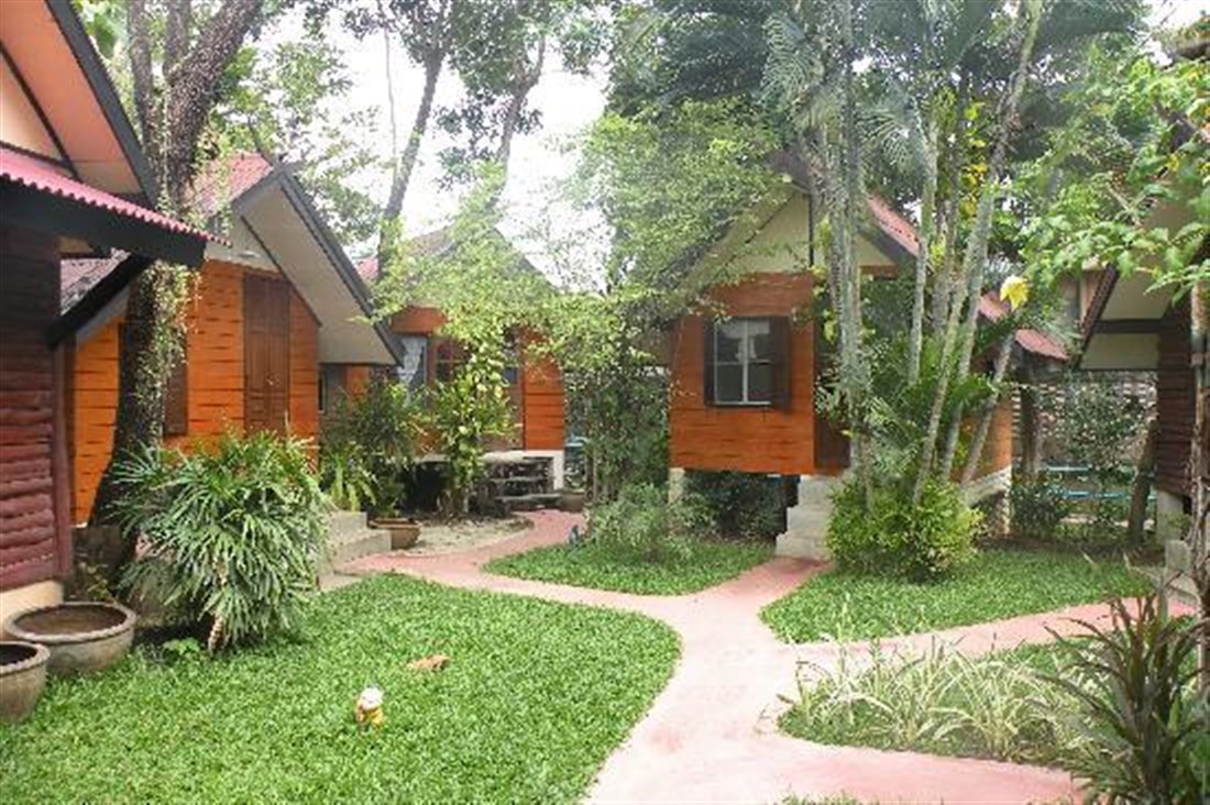 Row of wooden bungalows and garden paths at Ban Thai Guesthouse