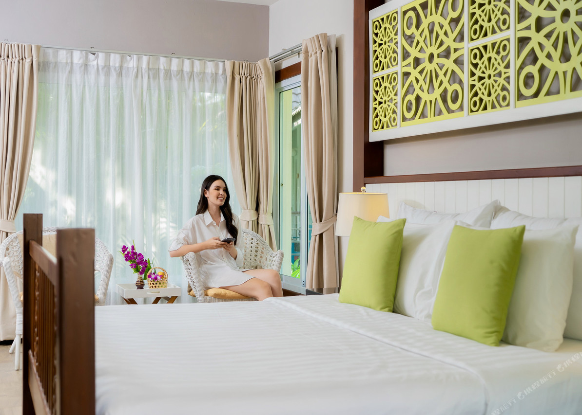 Thai-style guest room in white and green tones with garden view