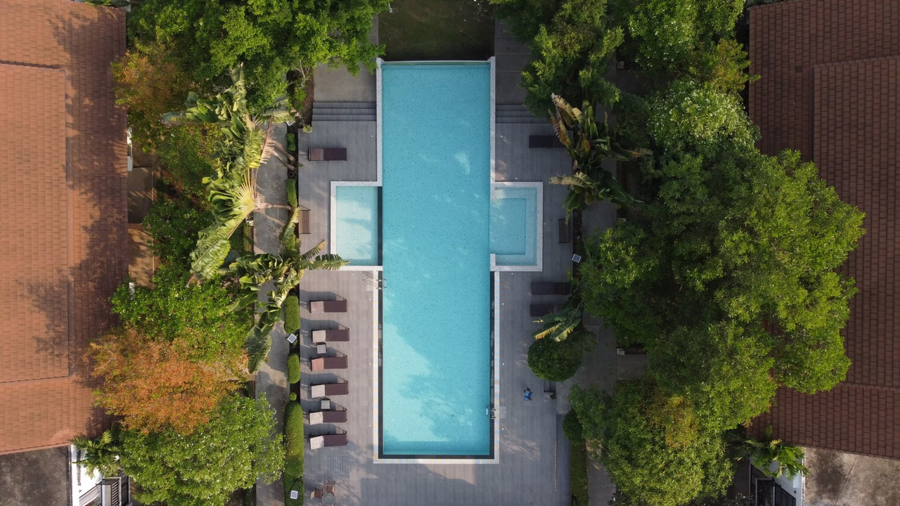 Long saltwater pool with terracotta-tile-roofed villas