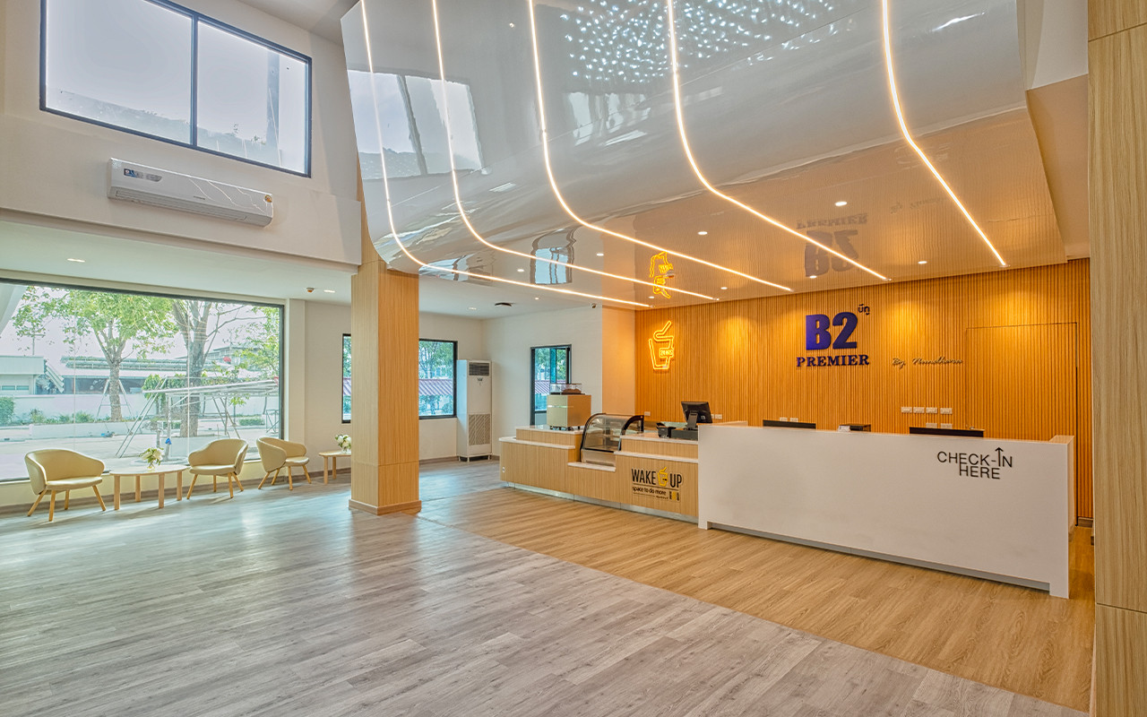 Lobby and check-in counter with the Wake Up cafe in light-wood tones