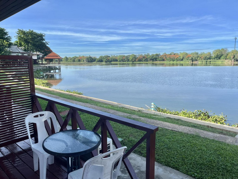 Lakeside room balcony with table and chairs facing the wide Bueng Chawak water