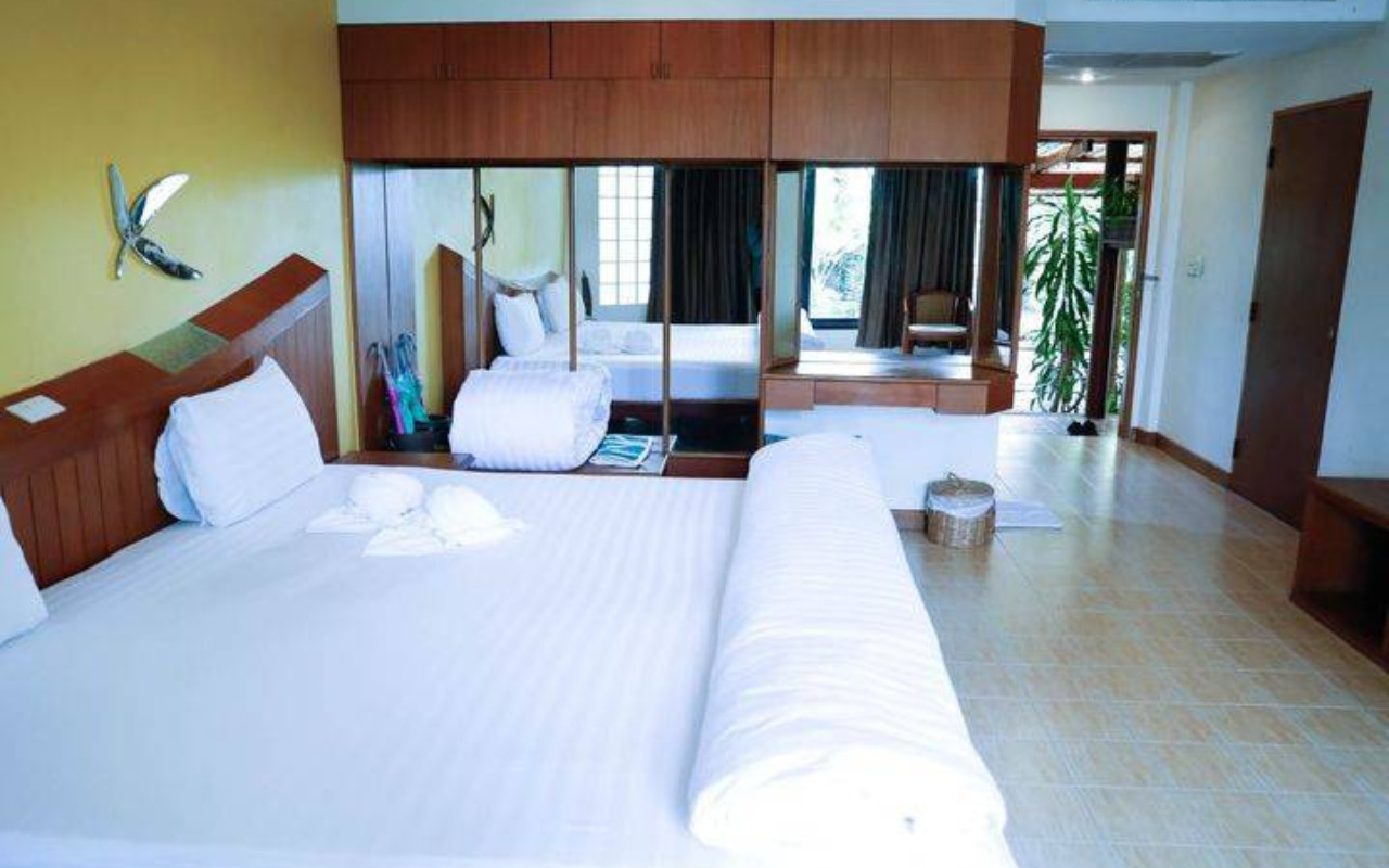 Large guest room with king bed, mirrored wardrobe, and a door out to the garden